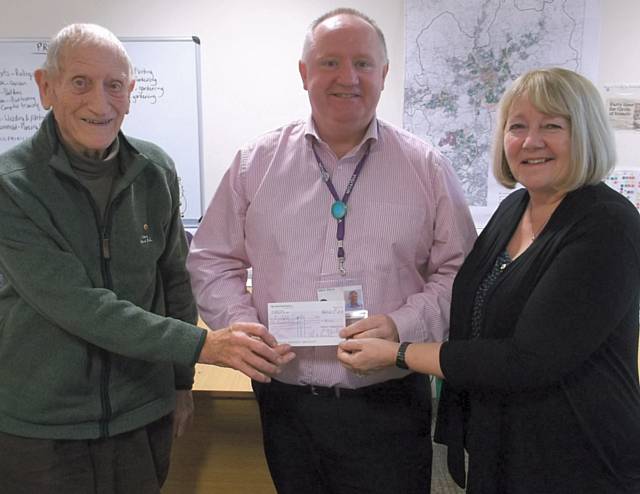 Ted Mutimer (left) presents a cheque to Mark Wynn of Rochdale Circle CIC helped by Lynn Butterworth