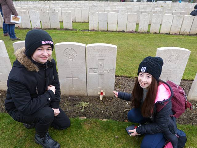 Alex Dempsey and Georgia Fish place a poppy and cross on the grave of Private S Fletcher who lived at Rawstron Street, Whitworth