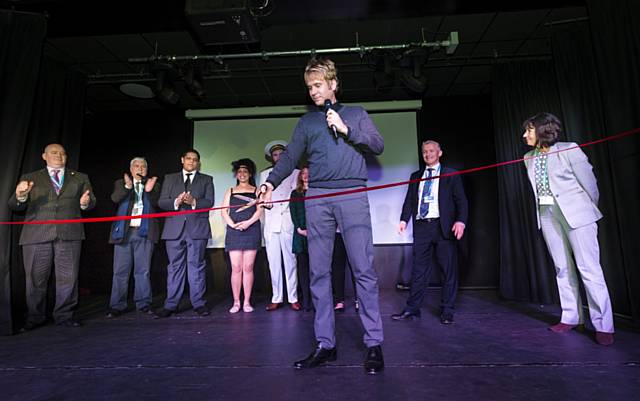 Hopwood Depree cutting the ribbon at the opening of the new Hopwood Theatre in front of College staff, students and invited guests
