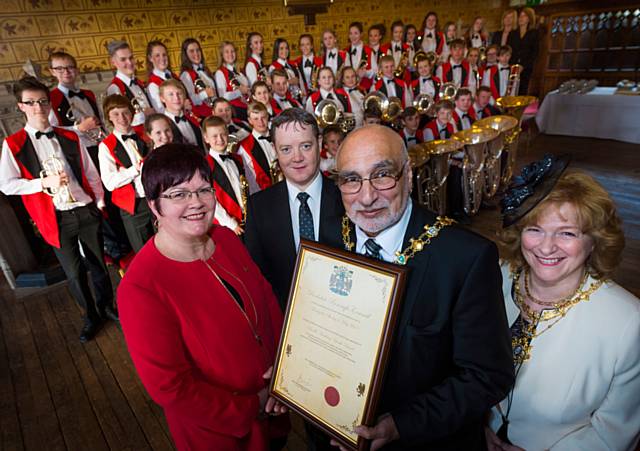 Mayor and Mayoress Surinder and Cecile Biant hand the citation to Wardle Academy Youth Band’s Director of Performing Arts, Councillor Janet Emsley and Musical Director, Lee Rigg.