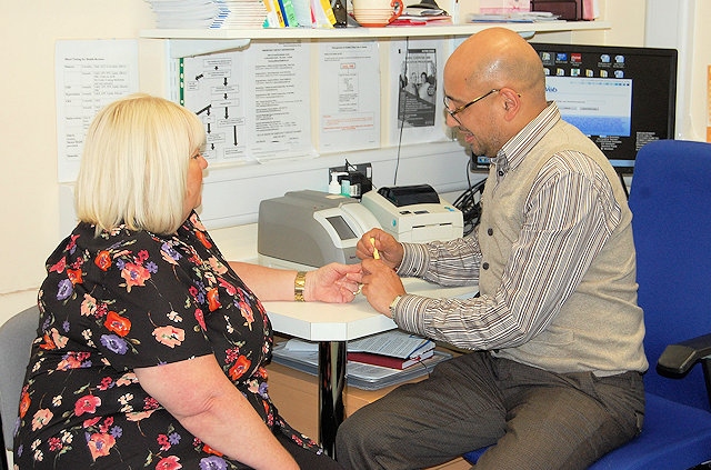 Dr Gupta from Pennine Surgery, Littleborough with patient having a fingerprick blood test to tell whether she needs antibiotics to treat her symptoms