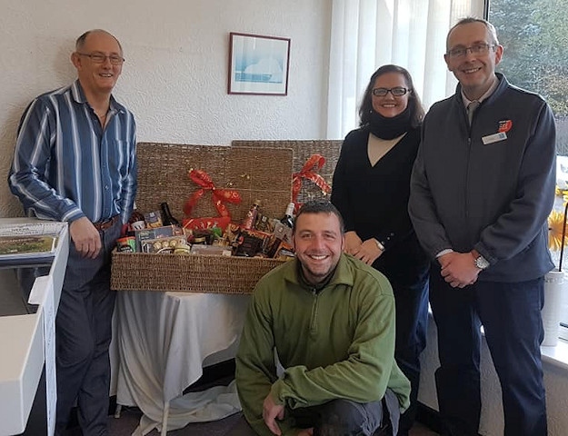 NEEVA Chairman Paul Ellison and Co-op manager Carl England with the Christmas hampers and NEEVA members, Amor and Andrew 
