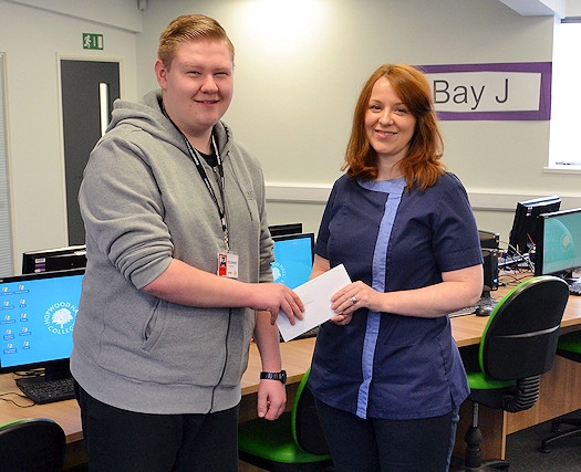 The Rochdale Ear Care Clinic owner Kath Scully presents Kieran Cullinan with a gift reward for his design