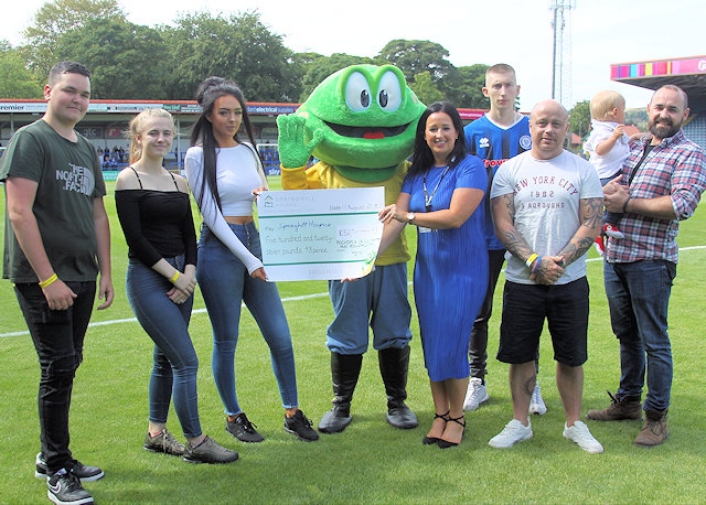 Springy the Frog receives a cheque  from Rochdale Football Club and The Skills Company