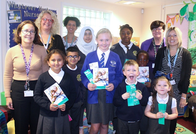Pupils at Broadfield Primary School celebrate the launch of the library card for every child scheme, with children's champion Erin Buckley, teachers and Councillor Janet Emsley, cabinet member for libraries