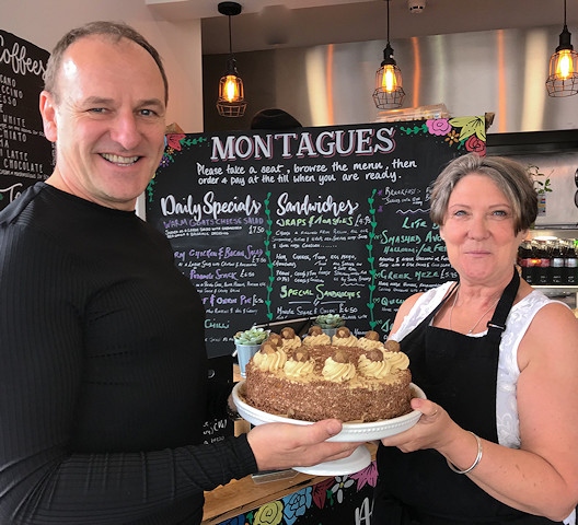 Greg Couzens receives a birthday cake from Debra McGinty, of Montagues Café