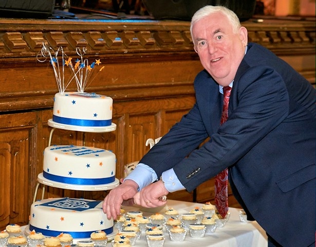 Pat Brennan cuts the cake to celebrate 25 years