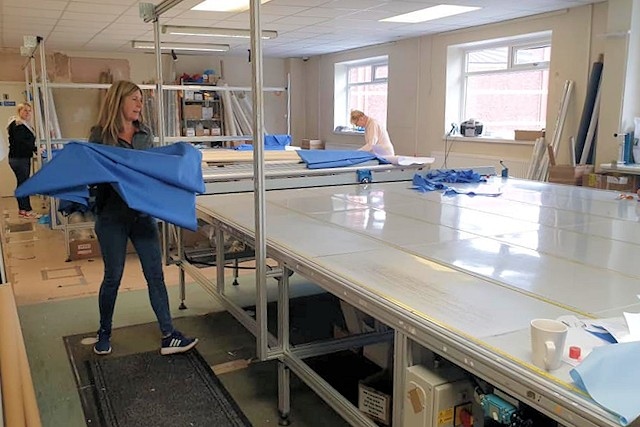 Staff at Mike Goldrick Blinds cutting out fabric to be made into scrubs