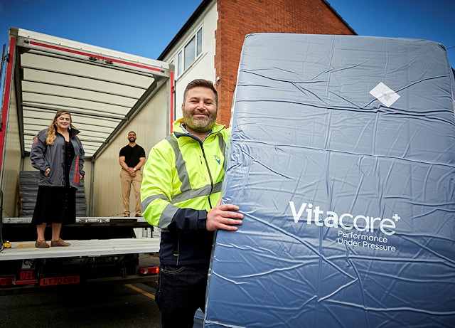 Adam Gittins, Operational Excellence Manager Conversion at The Vita Group (front) delivers the first batch of mattresses to Shelter