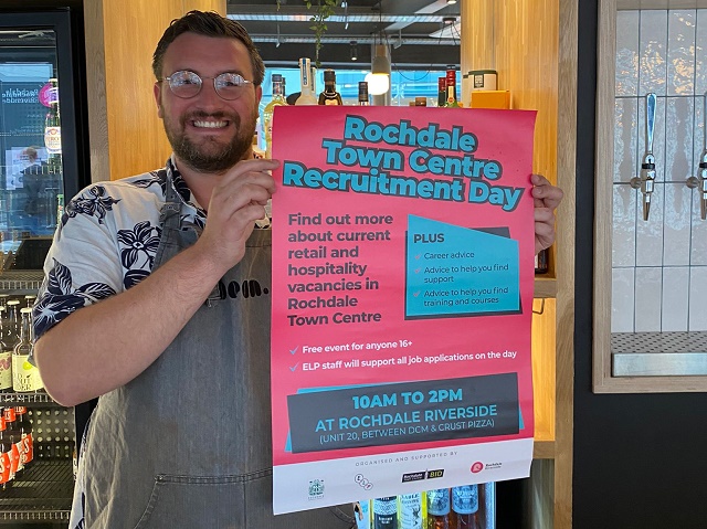 A Bean employee holds the recruitment day poster in the coffee shop