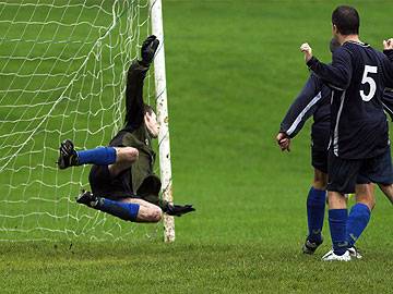 Rochdale Online goalkeeper Tim Makin attempts in vane to prevent Boundary Park scoring