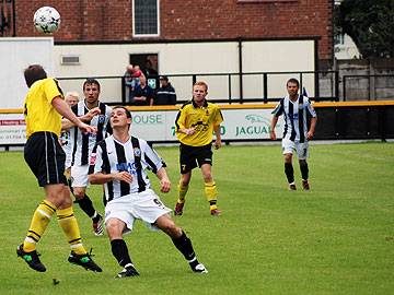 A Southport defender heads the ball away from Chris Dagnall