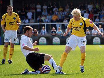 David Perkins is tackled in midfield