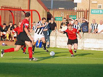 Rory Prendergast has the ball and two defenders for company