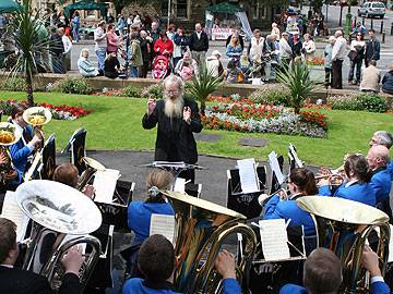 Crowds gather to watch the Todmorden Community Brass Band at the Littleborough War Memorial