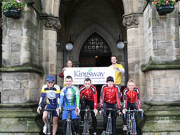 The cyclists with race organisers Howard Gott and Dan Griffiths holding sponsors Kingsway Development Park sign