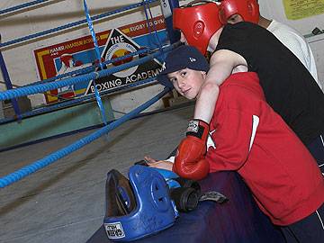 Spectators and boxers watch the action in the ring