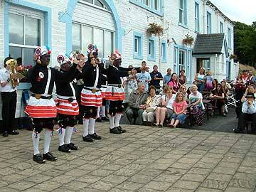 The Britannia Coconut Dancers perform outside the Wine Press at Hollingworth Lake