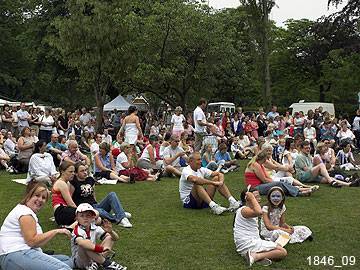 A large gathering enjoys an afternoon in the sun at Queen's Park