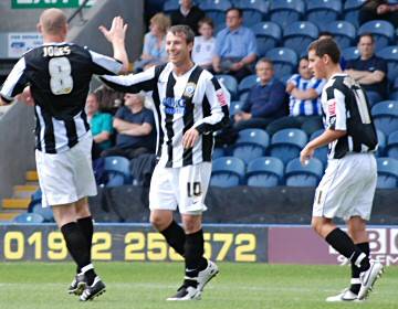 Le Fondre celebrates his second goal with Gary Jones and Adam Rundle