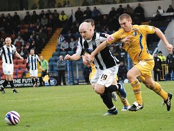 Goalscorer McEvilly shrugs off a Stags challenge