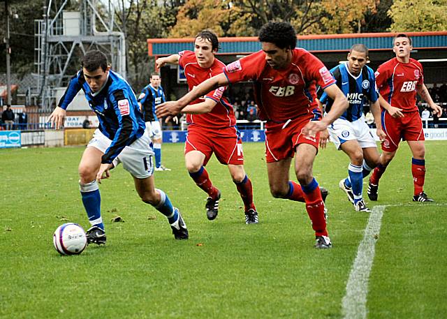 Adam Rundle looks to get past Anthony Charles.