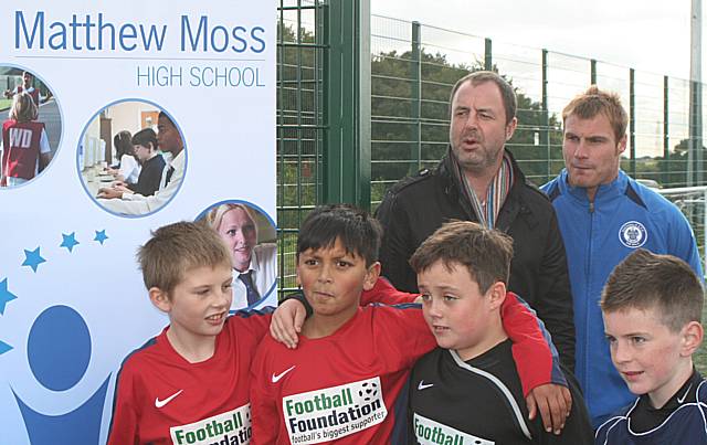 Rochdale manager Keith Hill and assistant Dave Flitcroft with young footballers from Siddal Moor Primary School at the opening of the new astroturf at Matthew Moss.