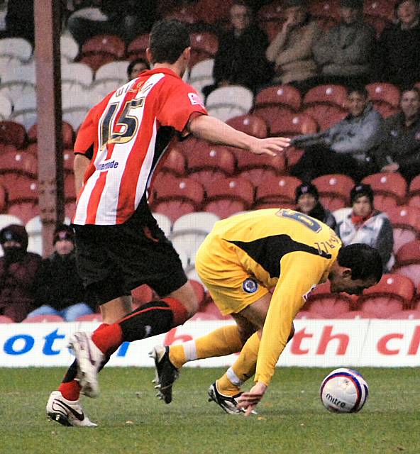 Chris Dagnall tries to keep his feet in the Brentford box.