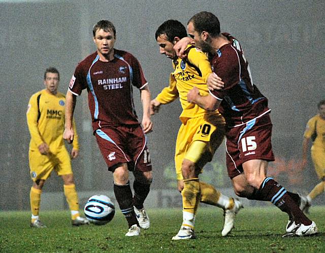 Le Fondre keeps hold of the ball under pressure from David Mirfin.