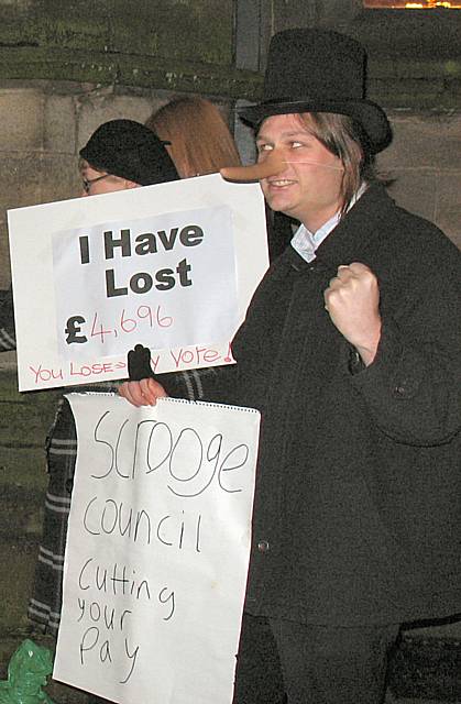 'Scrooge' protests outside the town hall.