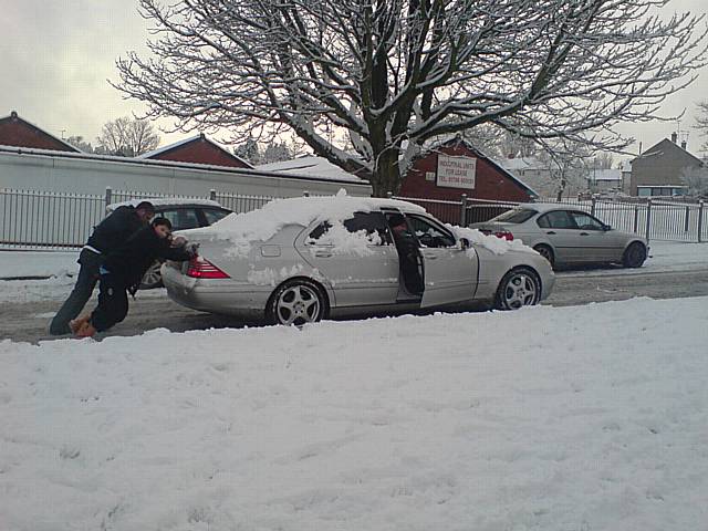 A family are forced to push their car up Bentley Street.