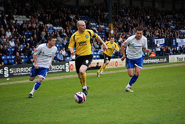 Gary Jones looks for a team mate after getting past two Bury defenders