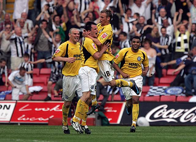 Rochdale players and fans celebrate Chris Dagnall's equaliser