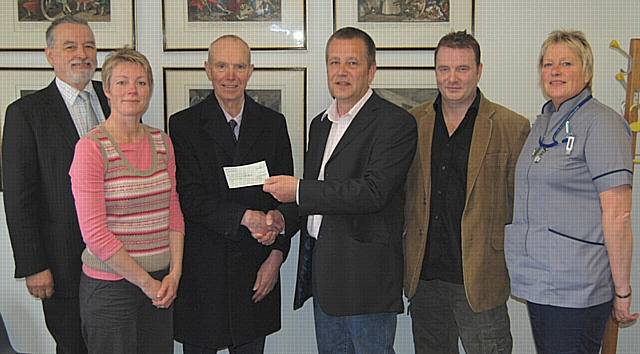 Brian Leather of Heywood Children’s Charities accepts a cheque from Arras People MD John Thorpe Tuesday afternoon in a ceremony. Pictured from left are Dr Michael Taylor; Louise Wileman, HV; Tony Mills of Arras People; and Viv Corcoran, HV Assistant