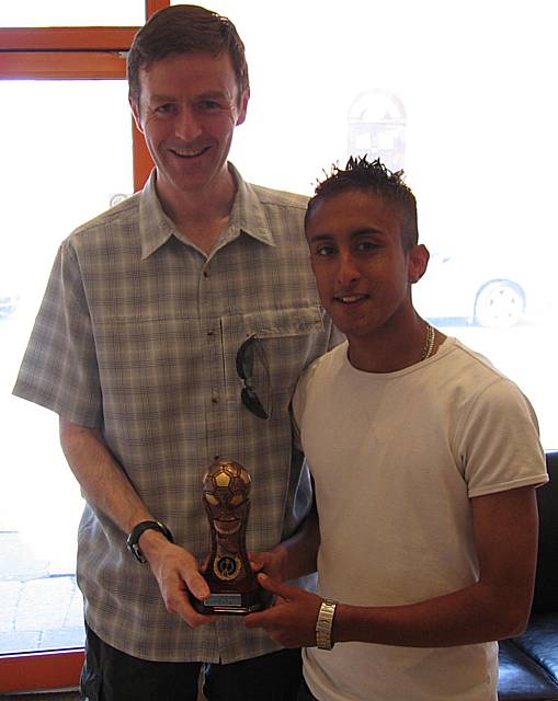 Jabar Khan receives the man of the match trophy from Rochdale Police Superintendent Bryan Lawton 