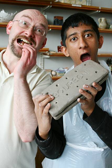 Art & Design tutor John Mikulin and Falinge Park pupil Younus Ali get stuck into the biscuits in the ceramics session