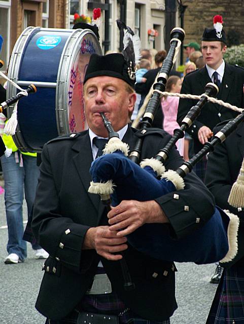 A member of the Oldham pipe band starts up a tune during last year's parade.