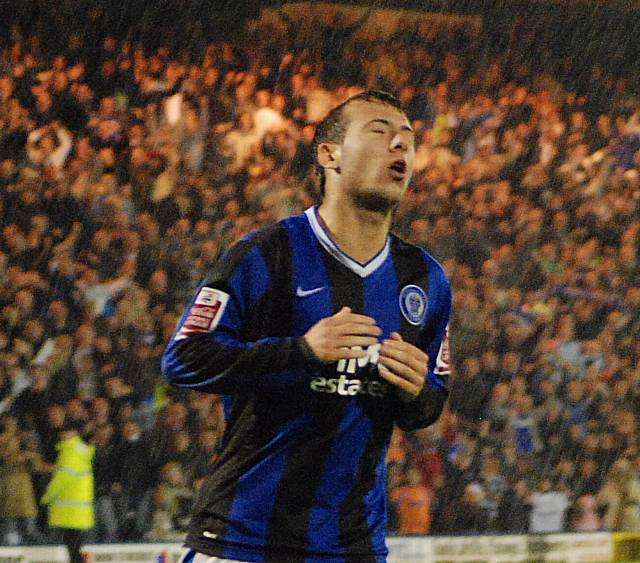 Adam Le Fondre is dismayed after his penalty miss as the Oldham fans celebrate in the background.