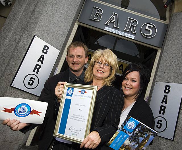 HIGH FIVE: Bar 5 owner Jayne Warcaba (centre) receives her Tidy Business Standards Charter certificate with Rochdale Council’s Gordon Beverly and Rochdale Town Centre Management’s Debbie O’Brien showing their support.