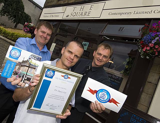 The Square Café in Littleborough owner Robert Wells (centre) holds his Tidy Business Standards Charter certificate presented by Rochdale Council’s Tommy Downes (left) and Gordon Beverley (right)