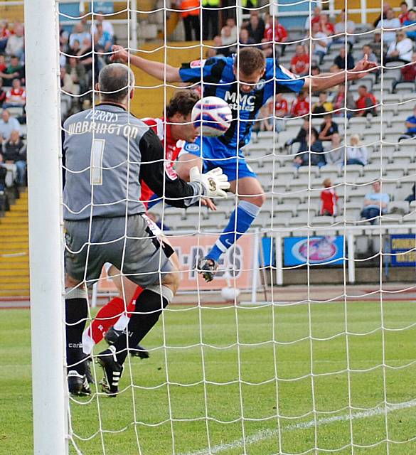 Rhodes' downward header is kept out by Andy Warrington.