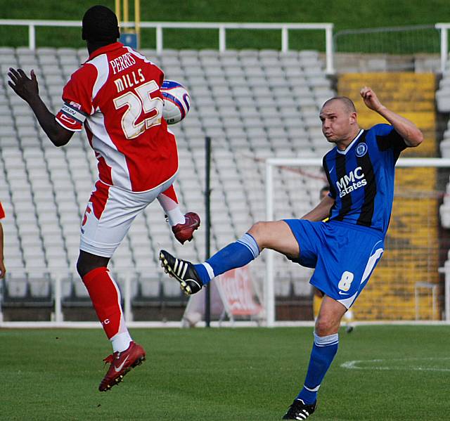 Mills and Gary Jones do battle in the middle of the park.