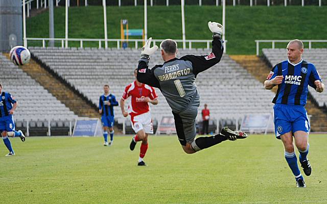 Warrington flies out of his goal to clear from Jones.