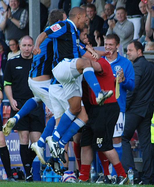 The players celebrate the late winner in front of the dugout.