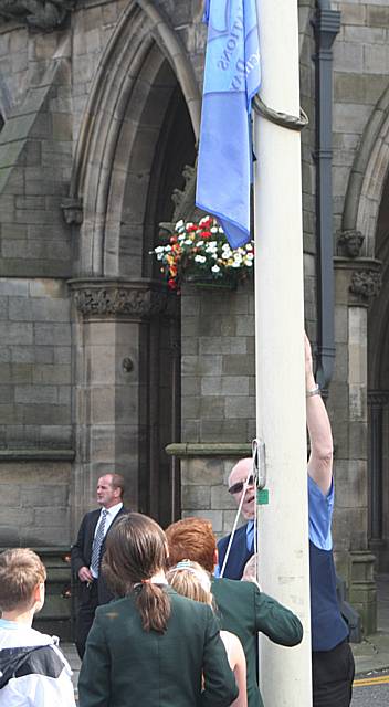 Local youngsters raise the flag of Peace at the Town Hall.