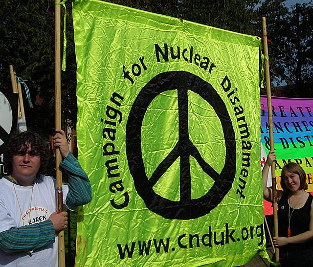 Thomas Gilligan and Kathryn Crawford preparing to carry the Campaign for Nuclear Disarmament banner, at the start of the demonstration.