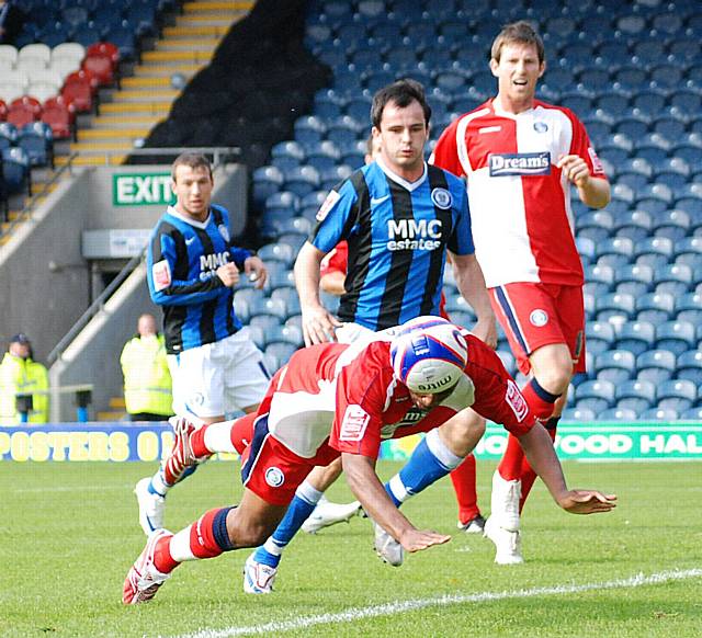 Leon Johnson heads the ball out for a corner in front of Dagnall.