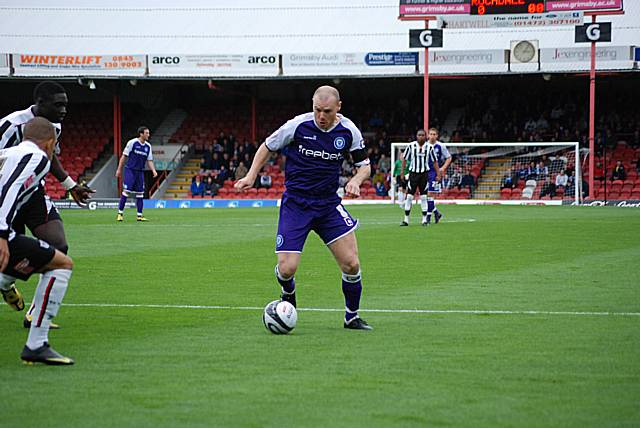 Gary Jones drives at the heart of the Grimsby defence.