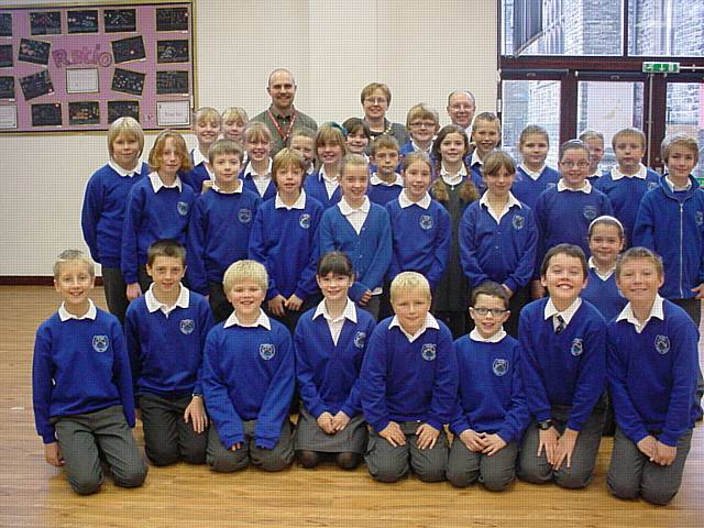 Smithy Bridge Primary School choir with (back row) conductor James Lewis, Rochdale Mayor Councillor Keith Swift and Mayoress Sue Etchells.