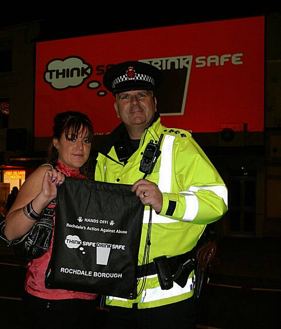 Chief Inspector George Fawcett hands a clubber a Think safe, Drink safe goodie bag aimed at encouraging safe and responsible drinking.